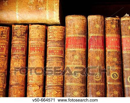 Stock Image - Old books in a shelf in a private house. Old edition of Don Quijote.. Fotosearch