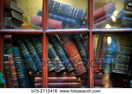 Old books stacked behind a window of a house in London, England, UK, Europe. View Large Photo Image Stock Photograph - Old books stacked behind a window of a house in London, England, UK, Europe.. Fotosearch