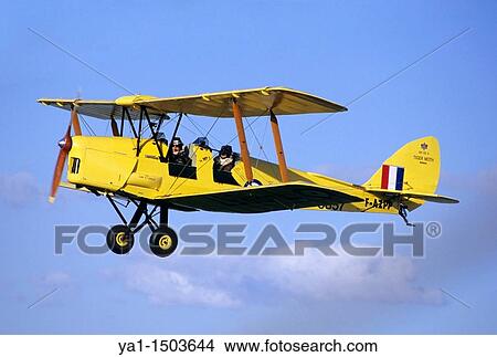 Old British trainer biplane De Havilland DH-82a Tiger Moth in flight over France View Large Photo Image Picture - Old British trainer biplane De Havilland DH-82a Tiger Moth in flight over France. Fotosearch