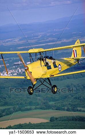Old British trainer biplane De Havilland DH-82a Tiger Moth in flight over France View Large Photo Image Stock Image - Old British trainer biplane De Havilland DH-82a Tiger Moth in flight over France. Fotosearch