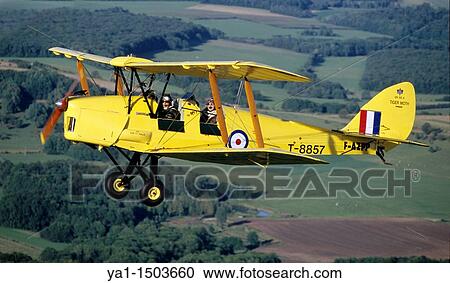 Stock Image - Old British trainer biplane De Havilland DH-82a Tiger Moth in flight over France. Fotosearch