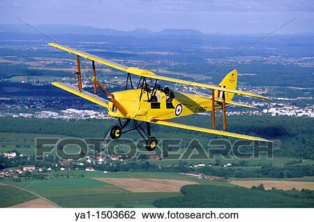Old British trainer biplane De Havilland DH-82a Tiger Moth in flight over France View Large Photo Image Stock Image - Old British trainer biplane De Havilland DH-82a Tiger Moth in flight over France. Fotosearch