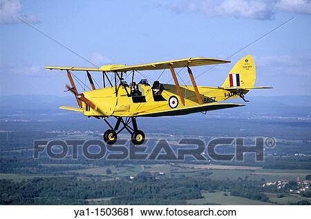 Old British trainer biplane De Havilland DH-82a Tiger Moth in flight over France View Large Photo Image Stock Image - Old British trainer biplane De Havilland DH-82a Tiger Moth in flight over France. Fotosearch