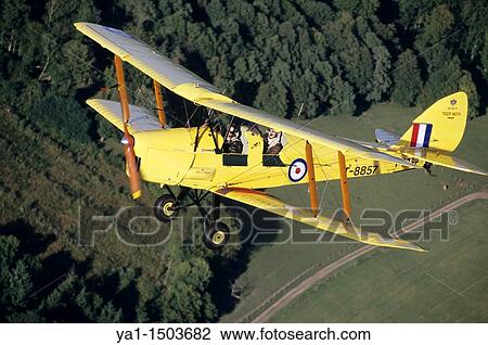 Old British trainer biplane De Havilland DH-82a Tiger Moth in flight over France View Large Photo Image Stock Image - Old British trainer biplane De Havilland DH-82a Tiger Moth in flight over France. Fotosearch