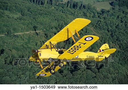 Old British trainer biplane De Havilland DH-82a Tiger Moth in flight over France View Large Photo Image Stock Photo - Old British trainer biplane De Havilland DH-82a Tiger Moth in flight over France. Fotosearch