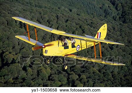 Old British trainer biplane De Havilland DH-82a Tiger Moth in flight over France View Large Photo Image Stock Photo - Old British trainer biplane De Havilland DH-82a Tiger Moth in flight over France. Fotosearch
