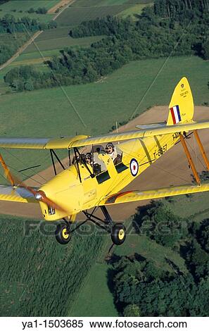 Old British trainer biplane De Havilland DH-82a Tiger Moth in flight over France View Large Photo Image Stock Photography - Old British trainer biplane De Havilland DH-82a Tiger Moth in flight over France. Fotosearch