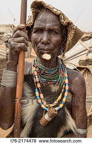 Stock Photo - old Dassanech woman in front of her hut in the Lower Omo Valley of Ethiopia.. Fotosearch