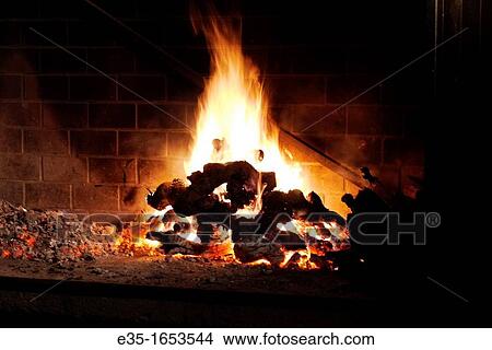 Picture - Old grapevines are used as fuel for a large outdoor oven,. Fotosearch