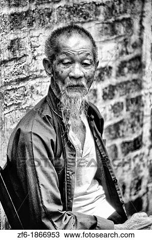 Old man in the old walled city of Kam Tin in the New Territories area of Hong Kong This is a dying breed of local for tourists with black clothes View Large Photo Image Stock Image - Old man in the old walled city of Kam Tin in the New Territories area of Hong Kong This is a dying breed of local for tourists with black clothes. Fotosearch