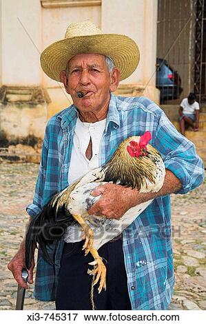 Old man smoking a cigar, carrying a cockerel, Trinidad, Sancti Spiritus Province, Cuba View Large Photo Image Stock Photo - Old man smoking a cigar, carrying a cockerel, Trinidad, Sancti Spiritus Province, Cuba. Fotosearch
