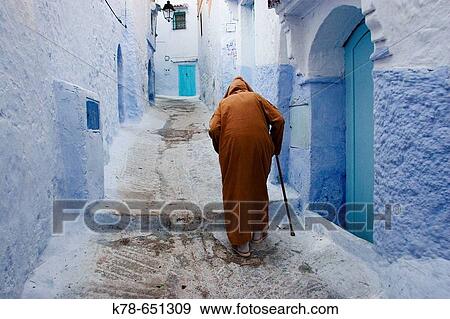 Old man walking in a typical street in Chefchaouen, Rif mountains region, Morocco. View Large Photo Image Stock Photo - Old man walking in a typical street in Chefchaouen, Rif mountains region, Morocco.. Fotosearch
