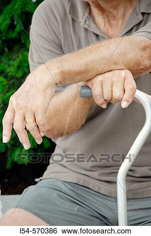 Stock Photograph - Old man with arms crossed on a walking cane. Fotosearch