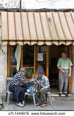 Old men talking outside a cafe in the centre of the bazaar area of Gjirokastra in southern Albania View Large Photo Image Stock Photograph - Old men talking outside a cafe in the centre of the bazaar area of Gjirokastra in southern Albania. Fotosearch