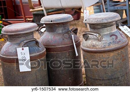 Picture - Old milk cans at auction during the Annual Mud Sale to support the Fire Department in Gordonville, PA. Fotosearch