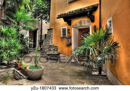 Stock Image - Old rustic patio with palm trees. Fotosearch