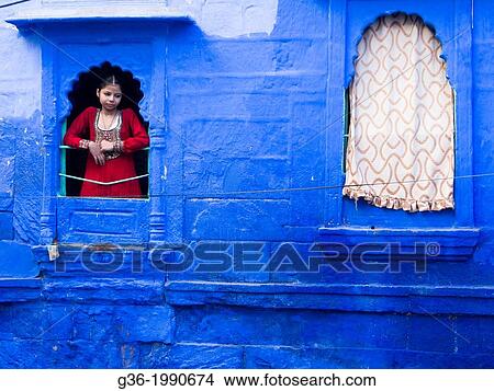 Old scooter parked next to a building, smiling girl looking out through window in Jodhpur, Rajasthan, India. View Large Photo Image Picture - Old scooter parked next to a building, smiling girl looking out through window in Jodhpur, Rajasthan, India.. Fotosearch