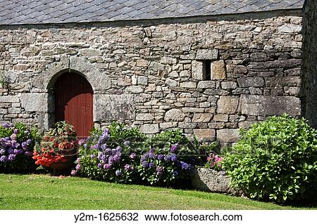 Old stone wall, doors and flower garden, Brittany, France View Large Photo Image Stock Image - Old stone wall, doors and flower garden, Brittany, France. Fotosearch