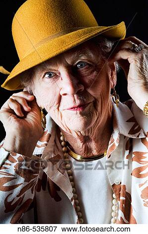 Old woman adjusting hat View Large Photo Image Stock Photo - Old woman adjusting hat. Fotosearch
