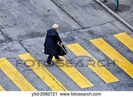 Stock Image - old woman on pedestrian crossing, view from above, Geneva, Switzerland. Fotosearch