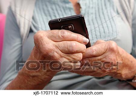 Stock Image - Old woman using smartphone. Fotosearch