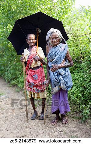 Old women with umbrellas. Santhal tribe. Jarkatand village, Bokaro district, Jharkhand. View Large Photo Image Stock Photo - Old women with umbrellas. Santhal tribe. Jarkatand village, Bokaro district, Jharkhand.. Fotosearch