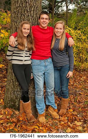 Older brother with his arms around his two younger sisters siblings View Large Photo Image Stock Image - Older brother with his arms around his two younger sisters siblings. Fotosearch