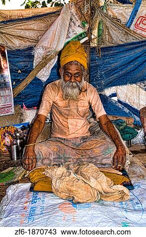 Stock Image - Older Hindu man in poor home by river in religious village of Mathura India. Fotosearch