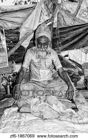 Stock Photo - Older Hindu man in poor home by river in religious village of Mathura India. Fotosearch