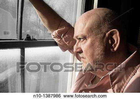 Stock Photograph - Older man by a window. Fotosearch