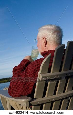 older man drinks lemonade on dock in chair View Large Photo Image Picture - older man drinks lemonade on dock in chair. Fotosearch