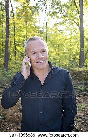 Older Man Speaking on Mobile Phone in a Forest View Large Photo Image Stock Photography - Older Man Speaking on Mobile Phone in a Forest. Fotosearch