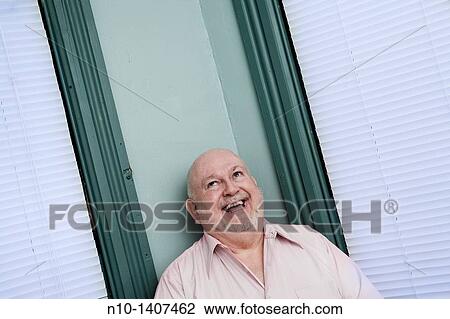 Older man standing between two windows View Large Photo Image Stock Image - Older man standing between two windows. Fotosearch