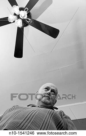 Older man standing under a ceiling fan View Large Photo Image Stock Photograph - Older man standing under a ceiling fan. Fotosearch