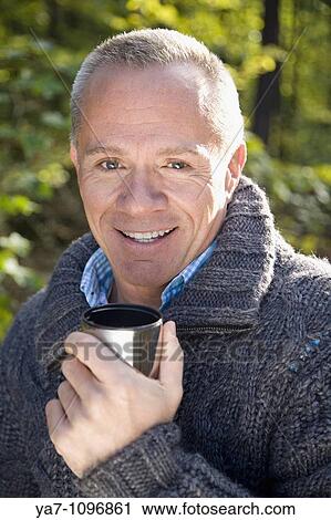 Older Man Walking in Woods Drinking from a Cup View Large Photo Image Stock Image - Older Man Walking in Woods Drinking from a Cup. Fotosearch