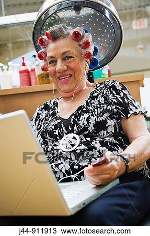 Older woman with laptop and headphones in hair salon, smiling, portrait View Large Photo Image Stock Image - Older woman with laptop and headphones in hair salon, smiling, portrait. Fotosearch