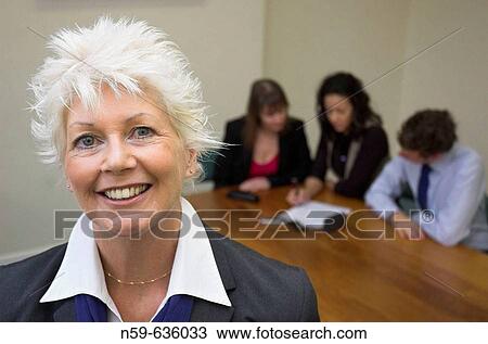 Older woman working in an office environment beyond retirement age. View Large Photo Image Stock Image - Older woman working in an office environment beyond retirement age.. Fotosearch