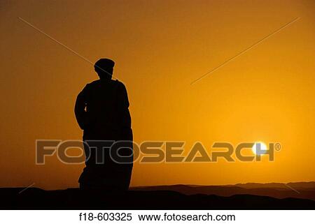 Omani man on the dunes, watching the sunset, northern edge of the Wahiba Sands, Oman View Large Photo Image Stock Photography - Omani man on the dunes, watching the sunset, northern edge of the Wahiba Sands, Oman. Fotosearch