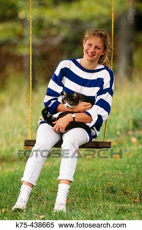 On swing with cat in her lap View Large Photo Image Stock Photography - On swing with cat in her lap. Fotosearch