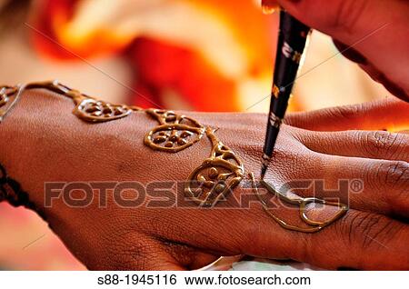 Stock Photograph - On the day of marriage in the morning, bride having henna painting.. Fotosearch