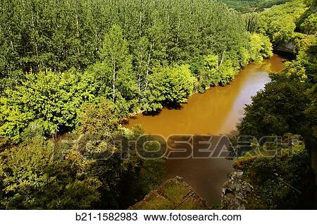 Stock Image - On the V? z? re river by the troglodytic medieval village of the Roque Saint Christophe -in the bottom, the port-, Dordogne, Aquitaine, France. Fotosearch