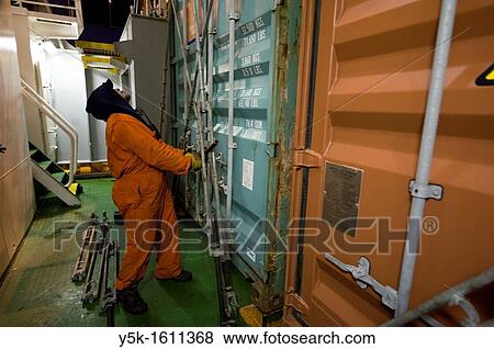 Stock Photo - One? Able Seamen? or sailor is receiving and placing new containers on the deck of container-vessel MV Flintercape, who sails from Rotterdam, Netherlands to Sundsvall, Sweden. The man is an Indonesian sailor.. Fotosearch