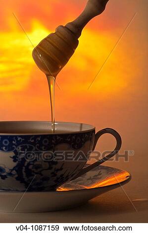 Stock Photo - One cup of hot steaming tea with dripping honey. Fotosearch