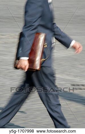 Stock Photo - one male commuter carrying briefcase in town. Fotosearch