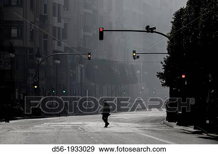 Stock Photo - One man alone crossing Colon Street during the Fallas MascletB, Valencia, Spain. Fotosearch