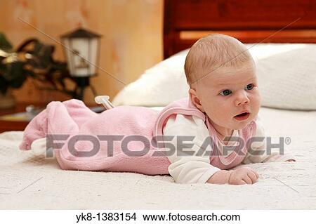 Picture - One month and two weeks old infant on bed. Fotosearch