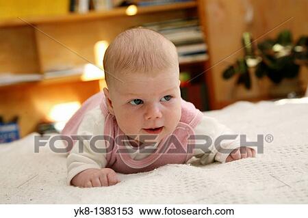 Stock Image - One month and two weeks old infant on bed. Fotosearch