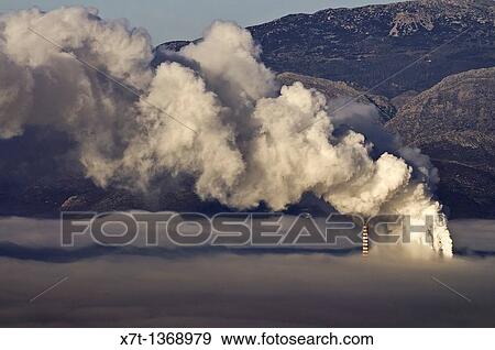 One of Megalopolis thermoelectric power plants shrouded in a mixture of fog, and smog from its own chimneys, Arcadia, central Peloponnese, Greece These coal and lignite burning, thermoelectric power plants supply electricity for Southern Greece View Large Photo Image Stock Photo - One of Megalopolis thermoelectric power plants shrouded in a mixture of fog, and smog from its own chimneys, Arcadia, central Peloponnese, Greece These coal and lignite burning, thermoelectric power plants supply electricity for Southern Greece. Fotosearch