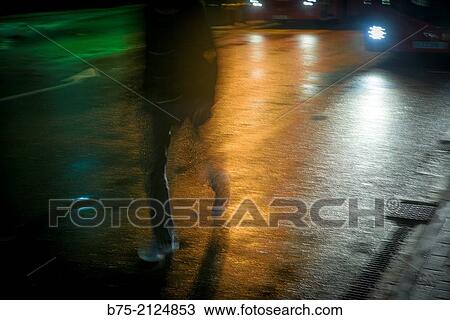 one unrecognizable man crossing the street in a hurry at night in London, England, UK View Large Photo Image Stock Image - one unrecognizable man crossing the street in a hurry at night in London, England, UK. Fotosearch