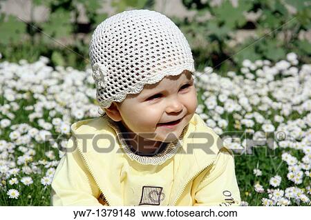 One year girl sitting and laughing on a daisy meadow View Large Photo Image Stock Photo - One year girl sitting and laughing on a daisy meadow. Fotosearch
